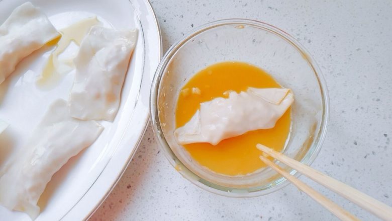 油煎苹果饺子,把包好的苹果饺子再在蛋液里滚一圈,各个面都裹上。