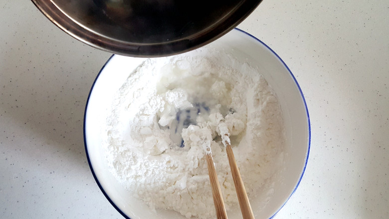 ~私房葱油饼☺,用温水慢慢倒入面粉中,搅拌。