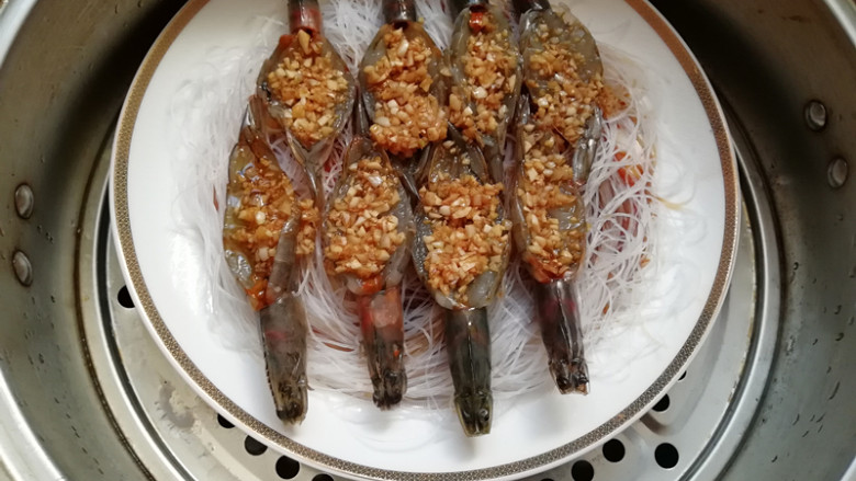 蒜蓉粉丝蒸大虾,蒸锅加水烧开,将盘在放入,上汽,盖上锅盖,蒸5分钟