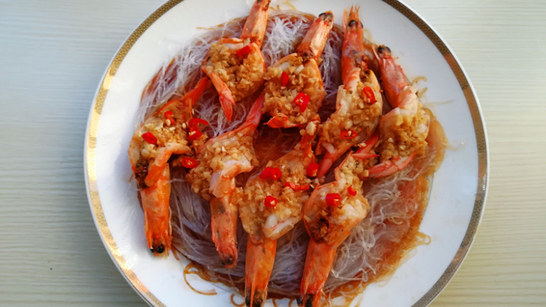蒜蓉粉丝蒸大虾,到时间后,将盘子取出,放上红辣椒圈,锅加油烧热,将每个虾上浇一点热油即可