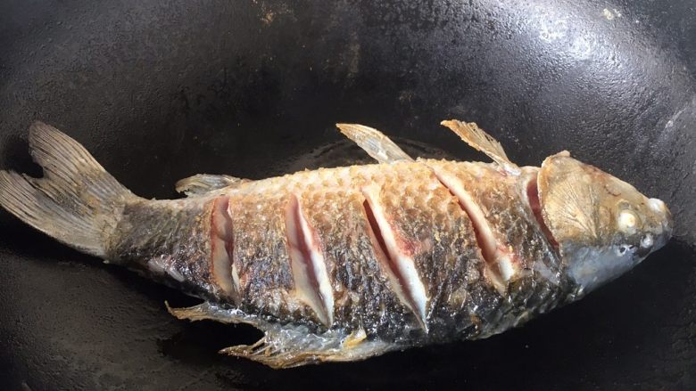 鲫鱼豆腐汤,当鱼的一面煎至金黄色时翻过来再煎另一面,两面都煎至金黄色就OK了。 温馨提示,当把鱼刚刚放到锅里后千万不要急于翻动,如果翻动了,肯定会粘锅的,因为油很热,鱼和铲子都是凉的,热油一下子就会“抱住”铲子和鱼,肯定会粘锅。那么我们什么时候才能翻动鱼呢,1,中火煎制至少1分钟后才能翻动。2,还有就是被煎鱼的那面两边会有明显的金黄色才可以翻动。3,再有就是当离火晃动锅时,鱼可随意在锅里滑动也可以翻动。建议初学者用第2种方法判断。 温馨提示,如果小伙伴选择的是大条的鱼,在翻动鱼时请用两把铲子翻动。