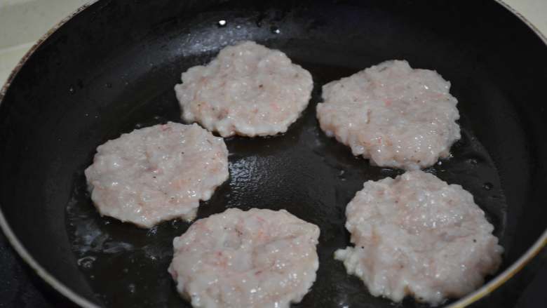 煎虾饼,用手快速摁成饼型,每个虾饼之间要有间距,防止粘在一起。