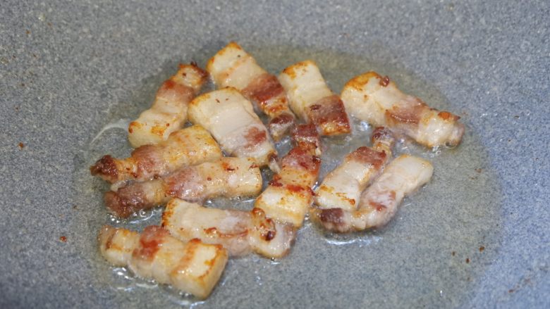 五花肉烧胡萝卜,一直煸炒至出油微焦,将肥肉部分的油逼出。