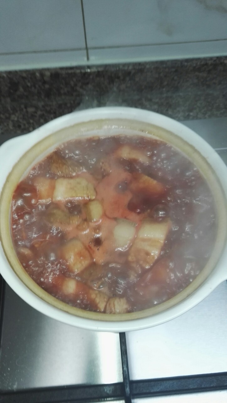家常砂锅南乳肉,把煸炒后的五花肉倒入小砂锅,加入适量开水,漫过肉。