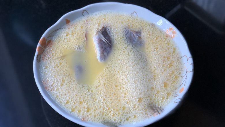 小黄鱼炖蛋,从冰箱里取出小黄鱼,冲一下水,洗去未融化的盐粒,放入蛋液中。