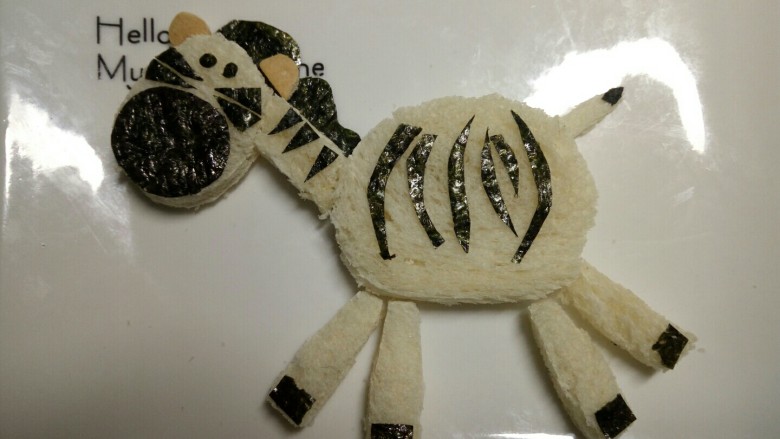 斑马土司,剪个水滴状的海苔做尾尖,剪四个小四边形做马蹄,剪若干个弯弯的海苔做身上的花纹