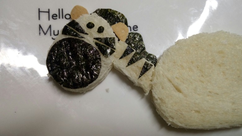 斑马土司,用土司边做出斑马的两个耳朵,用海苔剪个椭圆做斑马的脸部,剪个波浪状的海苔做鬃毛,再剪两个小椭圆做眼睛,剪若干个小三角形贴在脸部和脖子上
