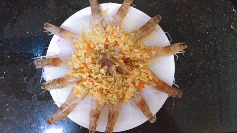 蒜蓉粉丝蒸虾,将蒜蓉辣椒淋在虾肉上
