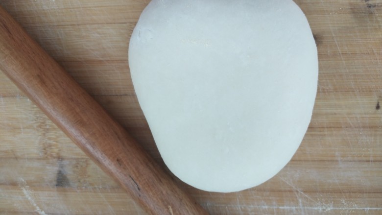 西红柿豆角焖面,面醒好了，揉一揉成光滑的面团，用擀面杖开始擀，注意案板上要先撒点玉米面粉防粘