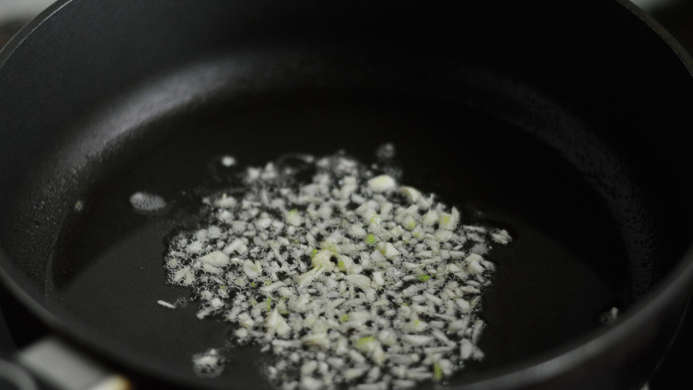 胡萝卜炒豌豆,锅里烧热油,爆香蒜蓉