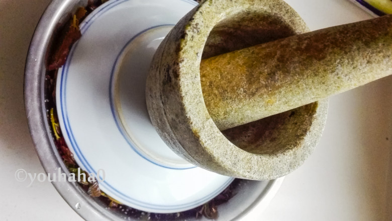 腌香椿芽,在上面倒扣一个平盘,上面压一个重物,我放了一个蒜臼子,腌渍2~3天左右