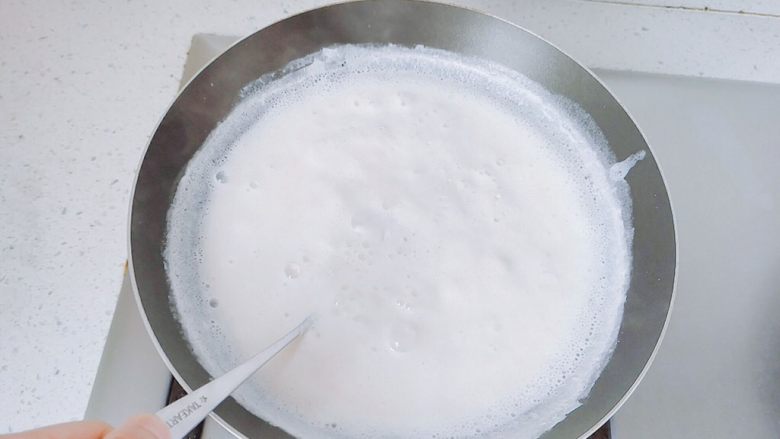 草莓菠萝炼乳,牛奶开了之后,换大勺子吧,会很烫手,可以事先准备好手套,还是不要停,继续搅拌。这个时候很容易糊,如果来不及搅拌,可以换成小火,那样熬的时间会久一点。