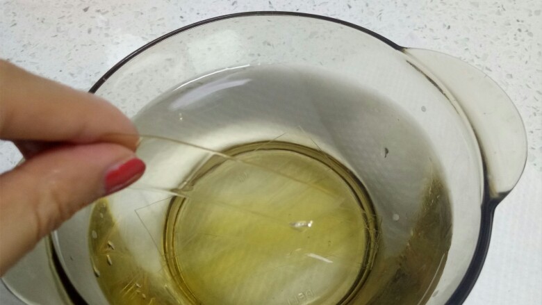 抹茶布丁,首先将一片吉利丁片(5g),剪成小细条,依次层叠浸入水中,泡软备用,泡10分钟以上即可