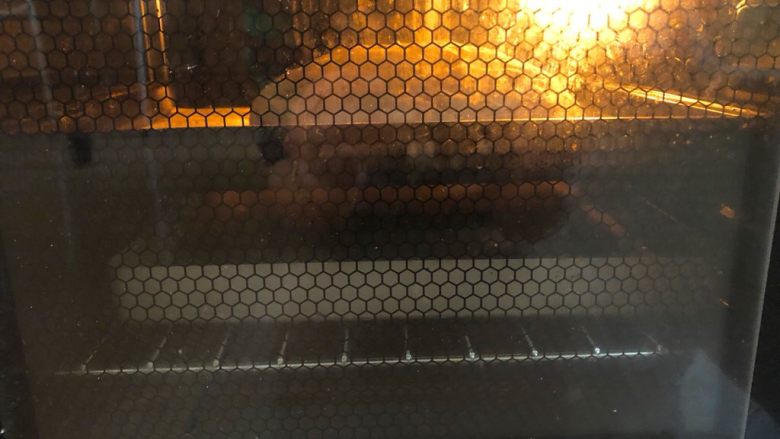 无油无糖燕麦芝麻欧包,烤箱中,下层各放一个空烤盘,230度预热5分钟。预热完成后,把面包放在中层的烤盘上,再下盘里注入200ml开水,形成蒸汽。烤5分钟后取出有热水的烤盘,继续烤25分钟。中途观察上色情况加盖锡纸。