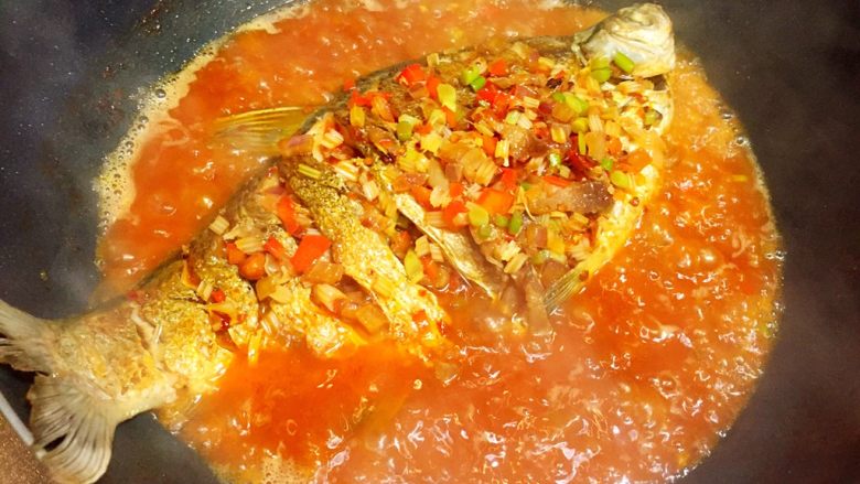 川味干烧臊子鱼,将锅里的料汁浇在鱼背上,转小火煮至汤汁浓稠即可。