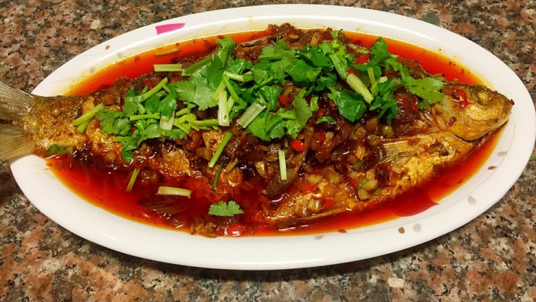 川味干烧臊子鱼,盛入盘中,撒上香菜就可食用啦!