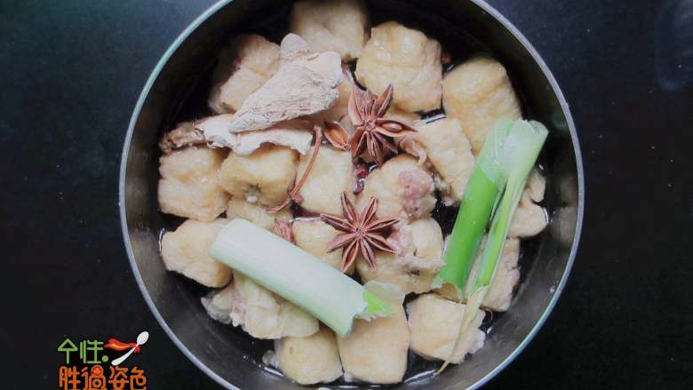 豆腐泡塞肉,锅里到少许油,把肉馅的一面小火煎一分钟,加入八角。葱段、姜片