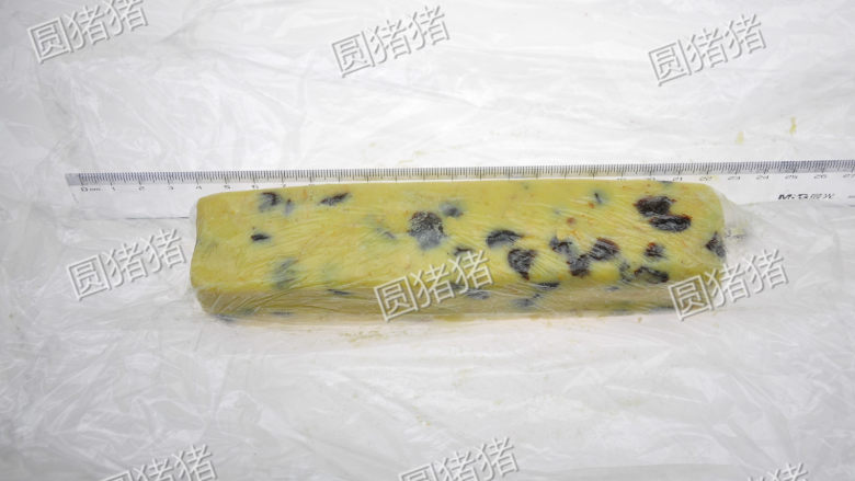 燕麦葡萄干酥饼,用一张保鲜膜将面团包裹起来,借用量尺将面团整形成4CMx4CM长条状。
