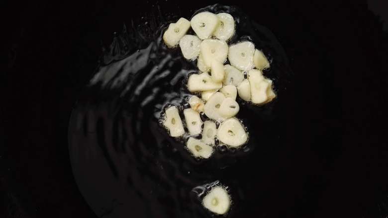 春天的味道-韭菜炒银芽,锅中倒入食用油,将蒜片下入,略微炒一下。