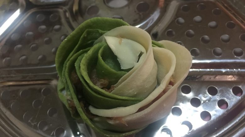玫瑰饺,卷到最尾处要粘点水,饺子皮才会捏紧。如图,就这样完成了第一个玫瑰饺。