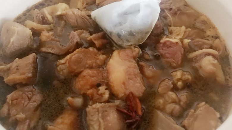 干豆角烧牛肉,牛腩颜色白一点关火,把牛腩倒进砂锅里面,茶包放进去,加生抽,老抽,盐,白糖和适量的清水,大火烧开后,小火闷