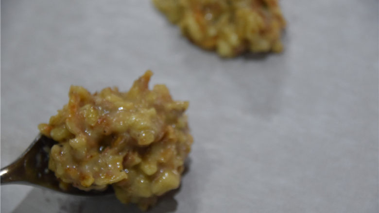 樱花虾坚果薄烧,然后用小勺,将面糊尽量平均地分布在油纸上。