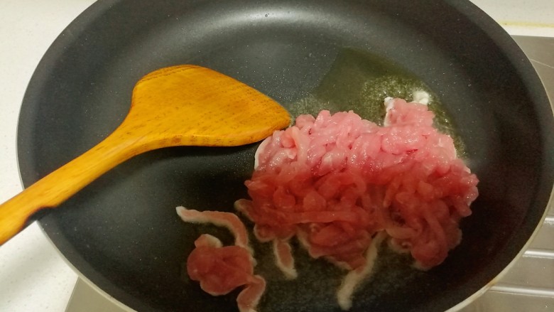 鱼香肉丝,锅内放色拉油,大火将油烧至7成热,放入腌好的肉丝。
