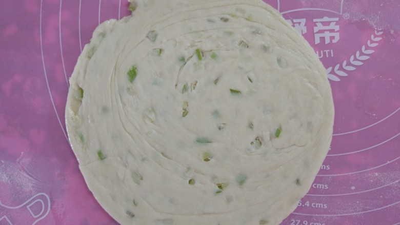烫面葱油饼,用手按扁,慢慢扩张擀成圆形。依次做好其他。