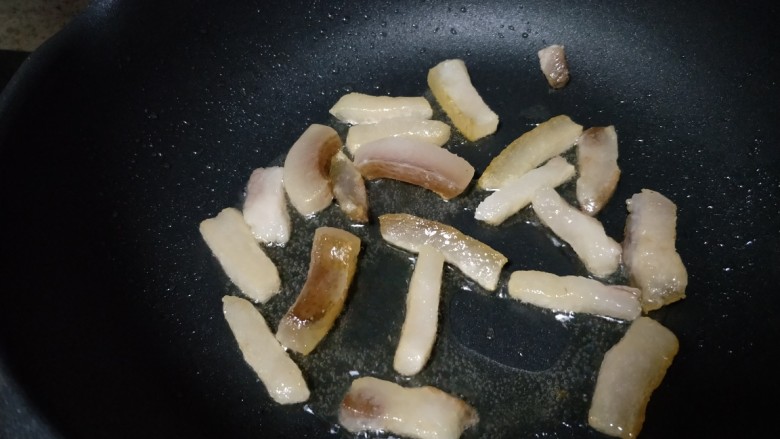 芦蒿炒腊肉,锅加热,倒入肥肉(不用加油,腊肉会出油)