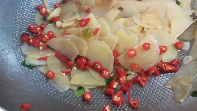 麻辣土豆片,加入切碎的小米椒辣椒的维生素含量比较高,高温容易破坏营养,所以辣椒在快要出锅前才放,这样菜也不会太辣。