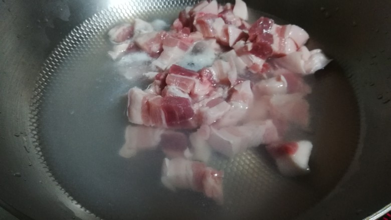 兰花干焖肉,炒锅放水,放入五花肉焯烫。