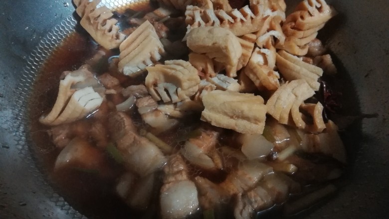 兰花干焖肉,把切好的兰花干放入肉中,一同焖煮。因为我的肉切的比较小块,而兰花干是经过高温油炸的,比较难入味。所以需要跟肉一同焖煮,才能入味。