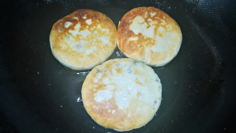 酸菜发面饼,底面上色后翻面,继续小火煎制,煎到两面金黄即可出锅,趁热享用