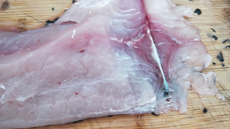 家常酸菜鱼,片鱼肉,如图所示,斜刀片鱼片,第一刀片刀鱼皮为止,不能切断。