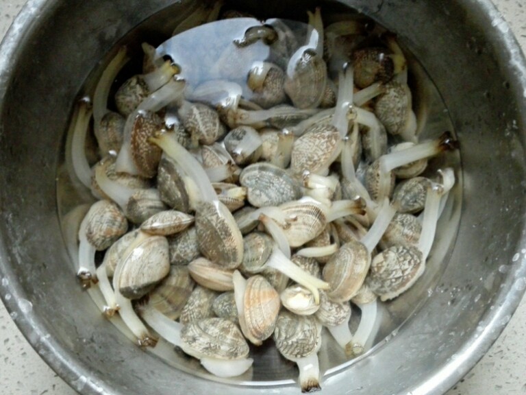 家烧花蛤,花蛤买来放淡盐水中让它吐净泥沙。至少要三四个小时,如果室温太高的话,最好放到凉爽的地方,绝对不能过夜,时间太长会死掉。然后冲洗几遍,洗净泥沙