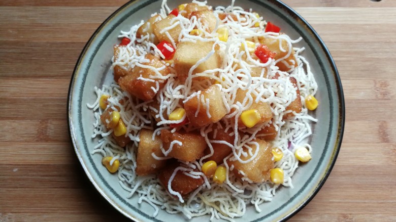 银丝馒头丁,然后将粉丝馒头丁装入盘中,在洒上炸好的玉米粒和红椒丁稍微装饰即可。