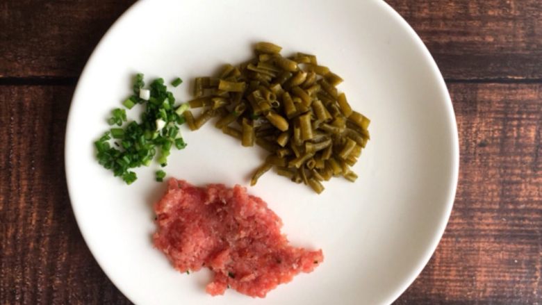 早餐系列之酸豆角肉末粉丝,将酸豆角浸泡一会沥干水分切小段，将香葱洗净切末，将猪肉洗净剁碎