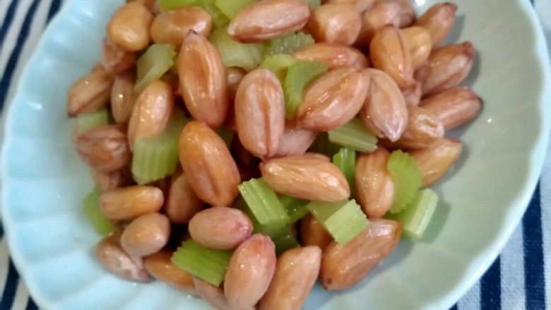 下酒小菜――凉拌花生,将食物和材料搅拌均匀后,取出装盘。