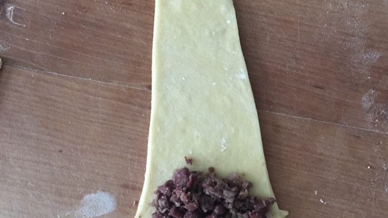 豆沙牛角包,面切一部分擀成三角长条,顶端放入豆沙。