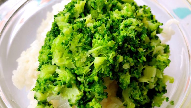 虾肉西兰花饭团,把熟米饭放进一个稍微大一点的容器(放边搅拌)加入切好的西兰花父碎