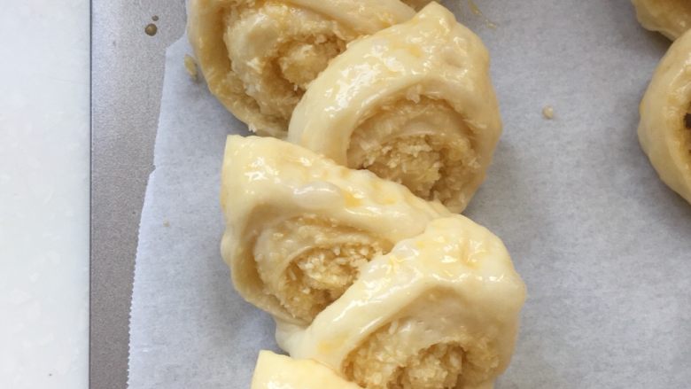 金灿灿的麦穗椰蓉面包,用剪刀从正上方斜着剪下去,然后整形至两侧,注意不要把面团剪断