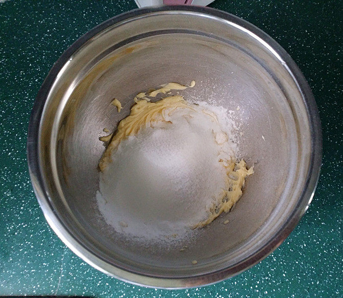 百香果磅蛋糕,接着筛入糖粉和细砂糖,再将黄油打至变白蓬松
