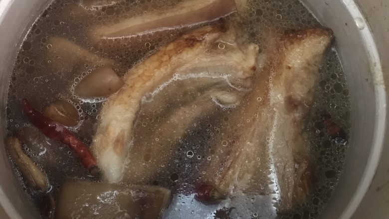 红烧肉,将炒好的五花肉,猪皮,香料倒入高压锅中。