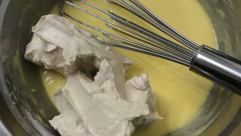 红糖戚风蛋糕卷(后蛋法),取三分之一蛋白放入蛋黄糊中,用手动打蛋器快速Z字形搅拌均匀