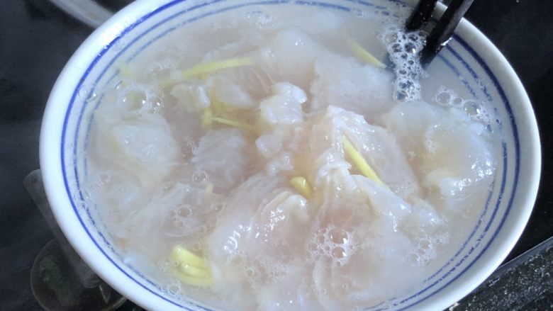 健身餐之西兰花龙利鱼片,水沸腾后舀两勺到腌鱼的碗里,烫出浮末,倒出,洗净鱼片,沥干。