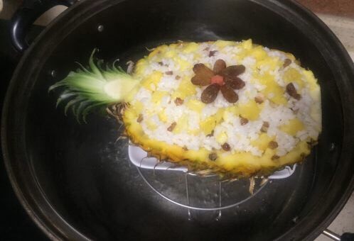 版纳香甜糯萝饭,蒸锅烧水,菠萝饭底部放个小盘,放入蒸锅