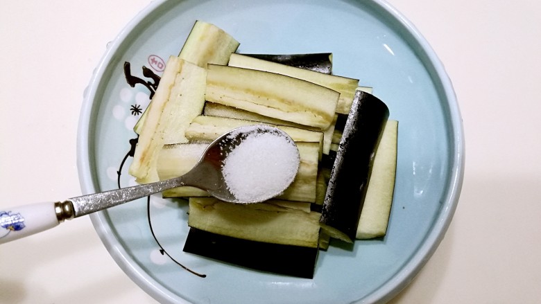 豆角烧茄子,将茄子放入适量的盐,拌均腌制一下。