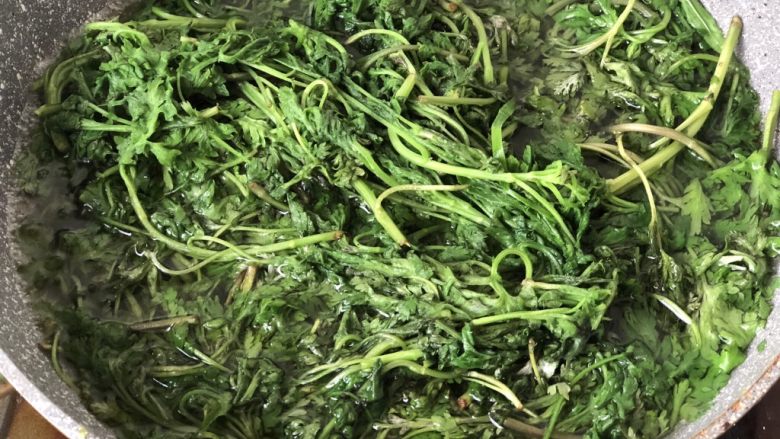 时令菜谱-网红艾草青团,锅里加水烧开,加入一勺盐,放入洗干净的艾草焯水,然后把水倒掉。