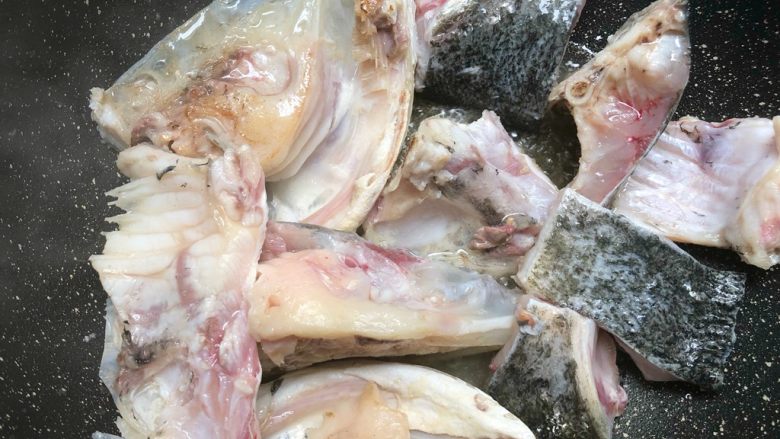 鱼头豆腐汤,热锅热油,放入鱼头,一面煎黄以后翻另一面继续煎