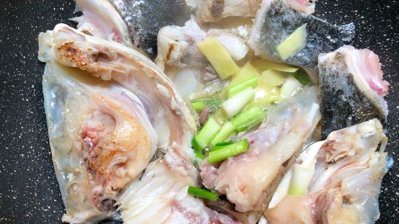 鱼头豆腐汤,俩面都煎好以后,放入姜片和葱段爆香